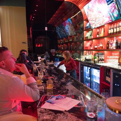 Interior, guests enjoying drinks and relaxing at a bar.