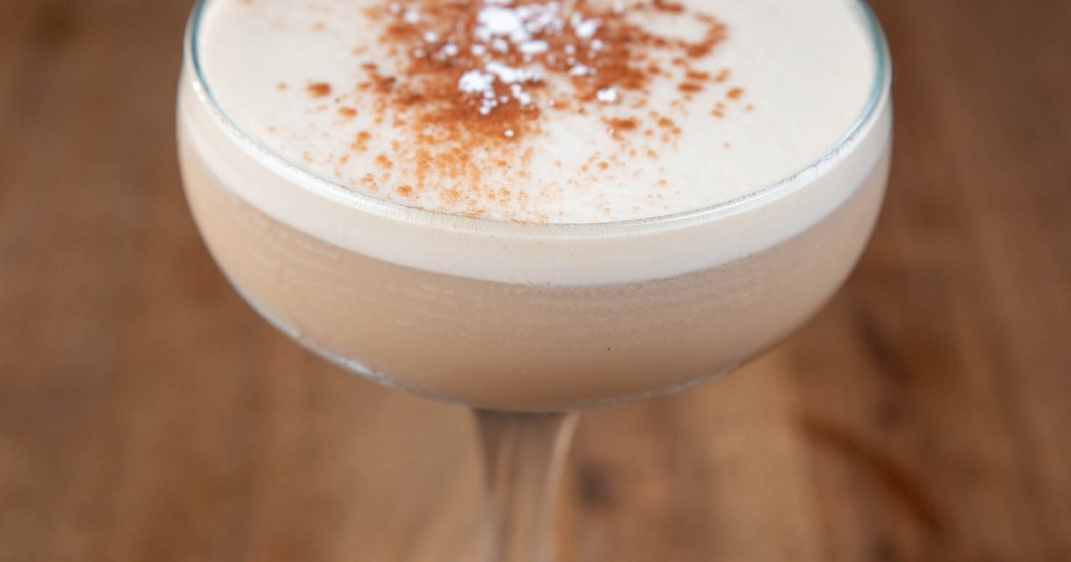 Espresso Martini cocktail sprinkled with cinnamon on a wooden surface