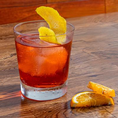 Negroni cocktail garnished with lemon peel.