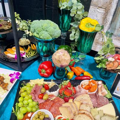 Colorful charcuterie board with meats, cheeses, fruits, and fresh vegetables.