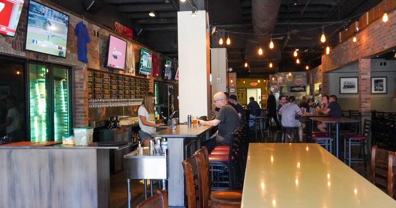Interior, bar and seating area with people enjoying drinks