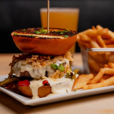 Mezzo's Melt Burger with a basket of fries and a beer.