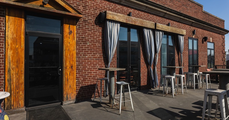 Outdoor seating area with high tables and stools