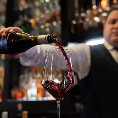 bartender pouring red wine.