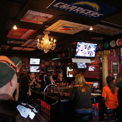 Behind the bar and patrons sitting around watching the game