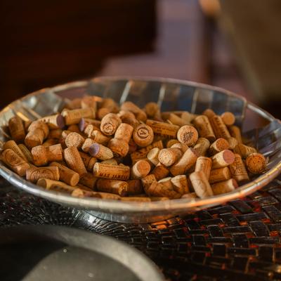 Interior, A bowl filled with various wine corks placed on a wooden table as a decoration.