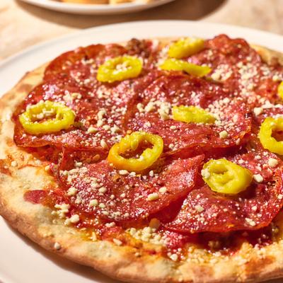 Pizza with spicy salami, banana peppers, and cheese.