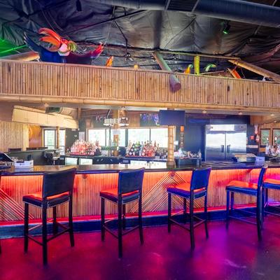 Tropical bar with bamboo decor and red lighting.
