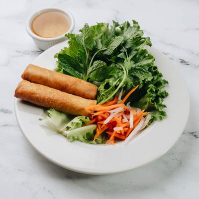 Fried Spring Rolls, served with fresh greens, pickled carrots, and a dipping sauce.