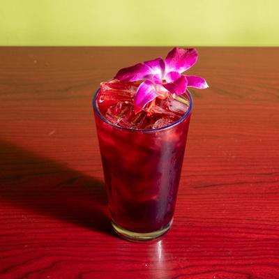 Berry Ice Tea served in a glass, garnished with pink orchid flower.