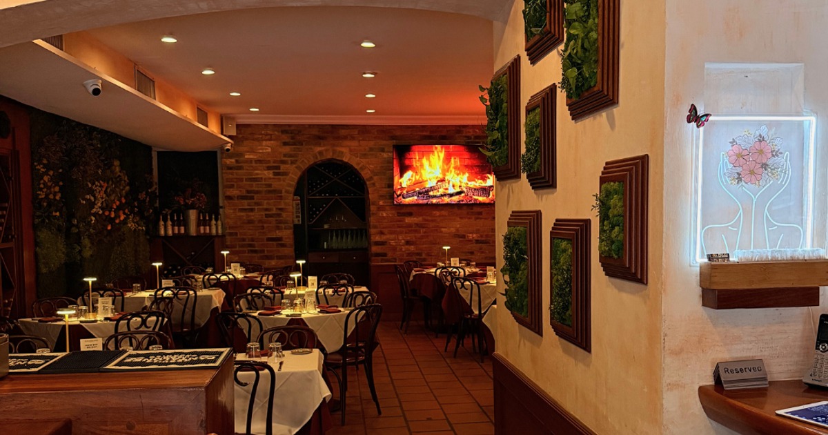 Restaurant interior with set tables and a brick wall fireplace screen