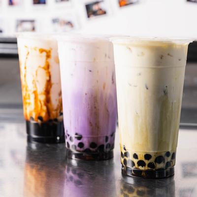 Three boba teas on a counter.