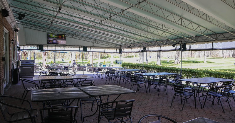 Wide view of covered outdoor seating area, tables and chairs
