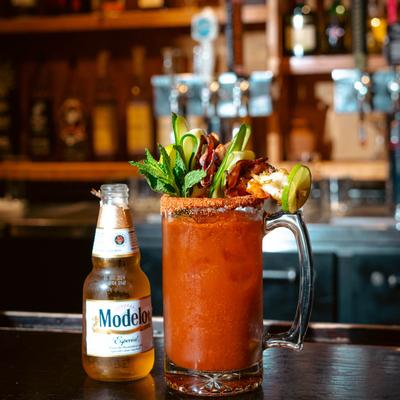 Michelada and bottled beer on a bar counter.