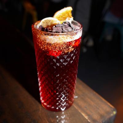 Cocktail served in highball glass, garnished with dry orange.
