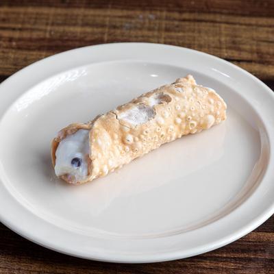 A cannoli on a white plate.