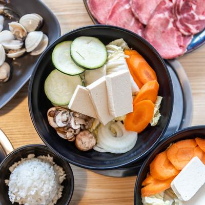 Top view of tofu and veggies bowl, white rice cup.