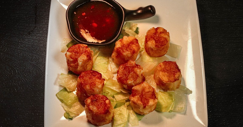 Shumai with chopped lettuce and sauce on the side