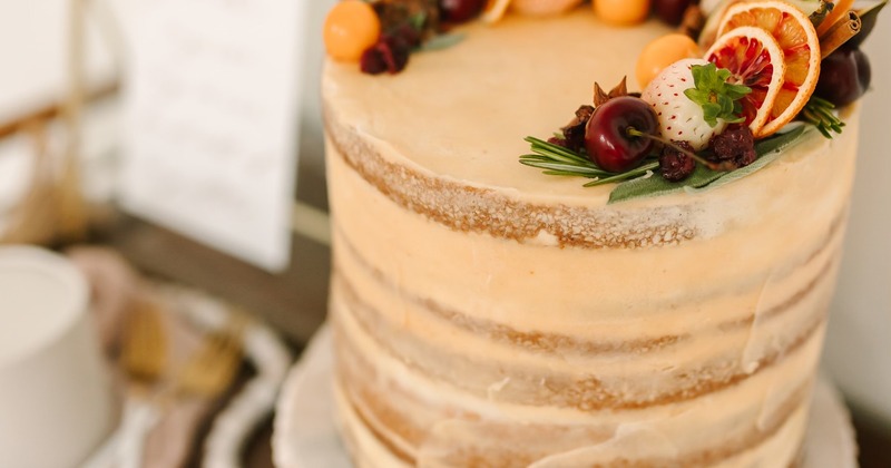 Elegant wedding cake topped with strawberries, cherries, dried citrus