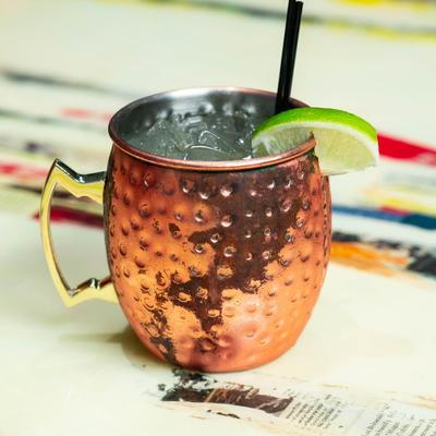 Tropical mule cocktail in a copper mug, garnished with a lime wedge.