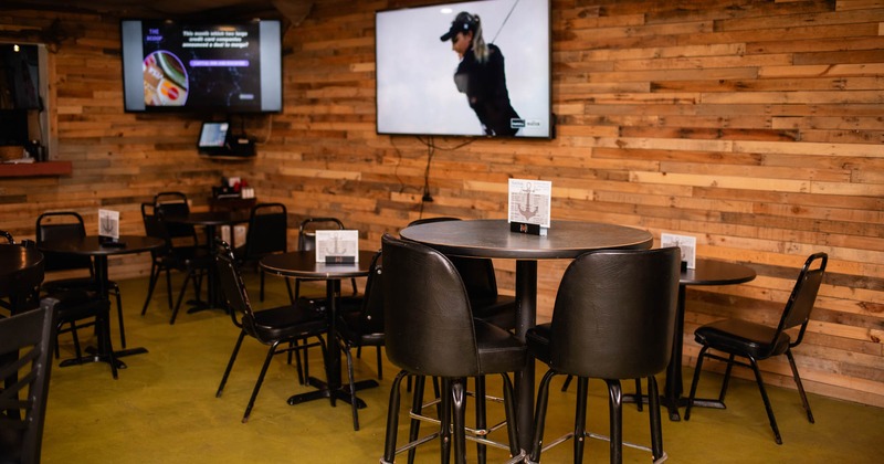 Interior, tall tables and bar stools, TV's on the wall