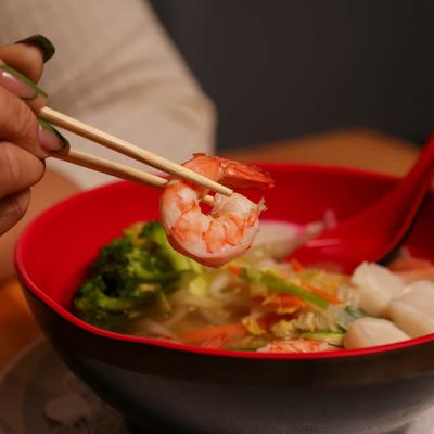 A person enjoying Seafood Nabe Yaki Udon.