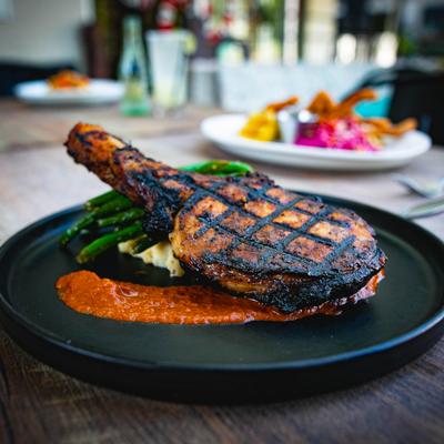 Tomahawk Ribeye with sides of mashed potatoes and asparagus.