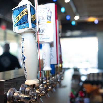 Bar, beer pouring pipe close up, bar area behind.