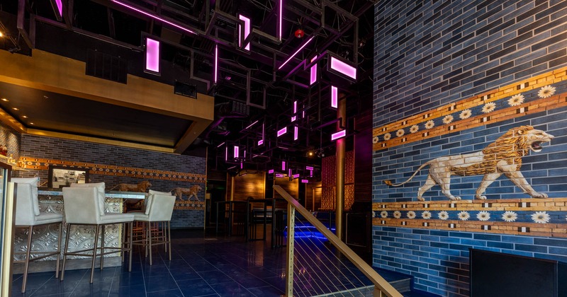 Bar area featuring a blue tile floor and  walls adorned with lion themed tiles