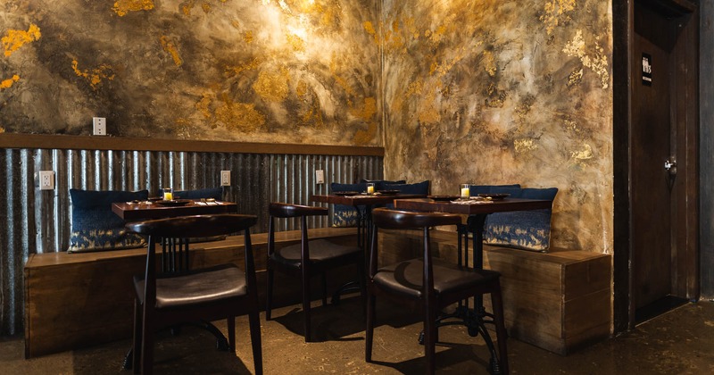 Interior, wall bench seating with pillows and set tables in the corner