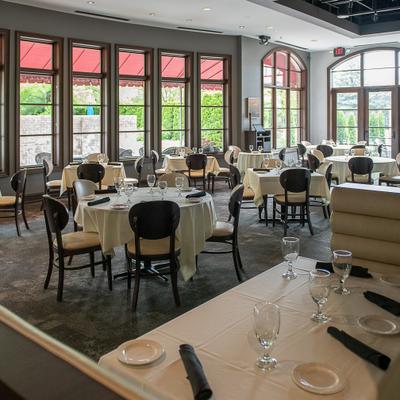 Dining area featuring large windows and numerus set tables.