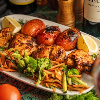 Chicken wings, served with grilled vegetables, front view.