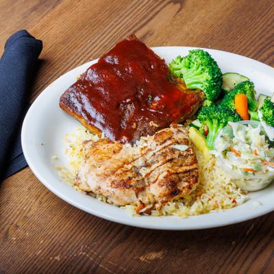 BBQ ribs and grilled chicken with slaw, rice, and veggies.