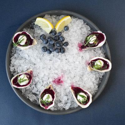 Oysters on ice with blueberries.