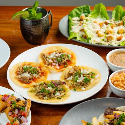 Mexican-style street tacos served with rice, beans, and a cocktail.