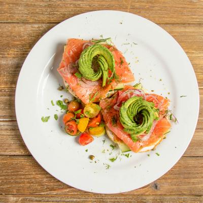 Smoked salmon with spiraled avocado, red onions and cherry tomatoes, top view