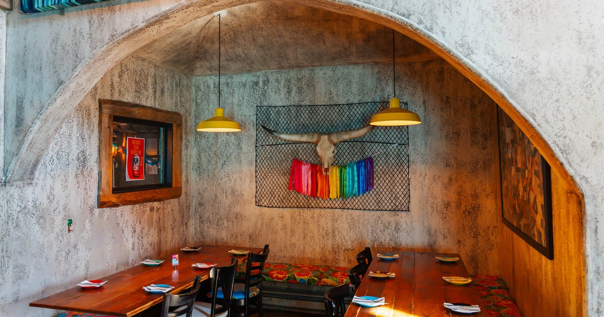 Rustic dining area with a wooden table, colorful benches