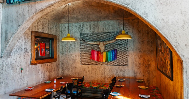 Rustic dining area with a wooden table, colorful benches