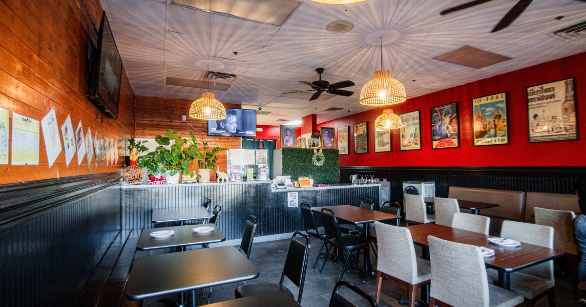 Interior of a cozy restaurant with tables, pendant lights, and wall decor