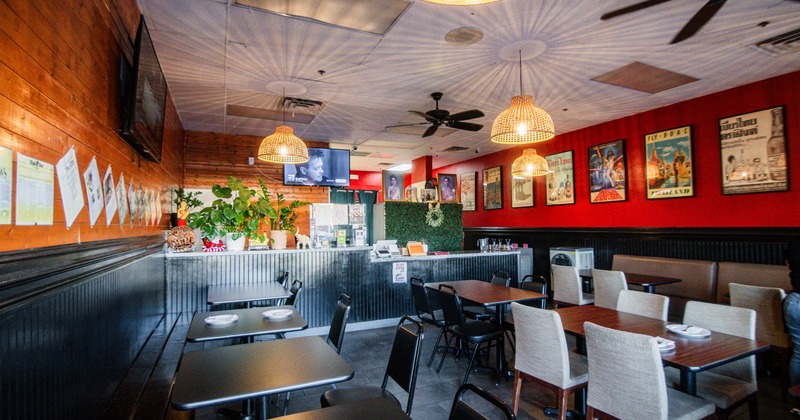 Interior of a cozy restaurant with tables, pendant lights, and wall decor