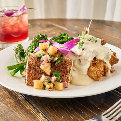 Blackened fish fillet and fried chicken smothered in gravy.