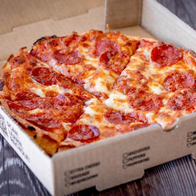 Pepperoni pizza inside an open takeout box.