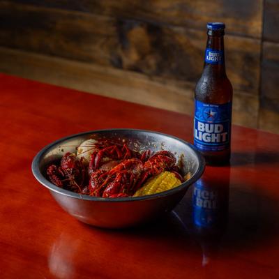 Crawfish with corn on the cob served with a beer.