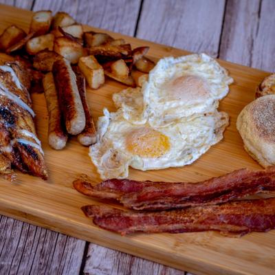 Combo breakfast platter with fried eggs, French toast, bacon, sausage and home fries.
