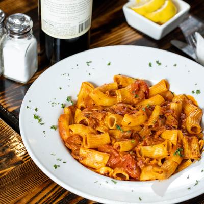 Rigatoni pasta in tomato sauce, with prosciutto, eggplant, garlic, onions, and cheese.