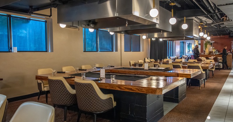 Modern restaurant interior of the dining area, tables with flat iron grill for food preparing