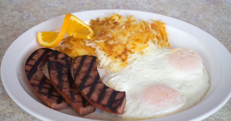 Breakfast plate with grilled meat, eggs, and hash browns