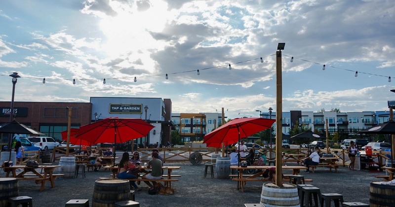 Outside, large space with tables and bench seating in front of Tap and Garden