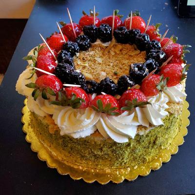 A cake adorned with ripe strawberries and berries.