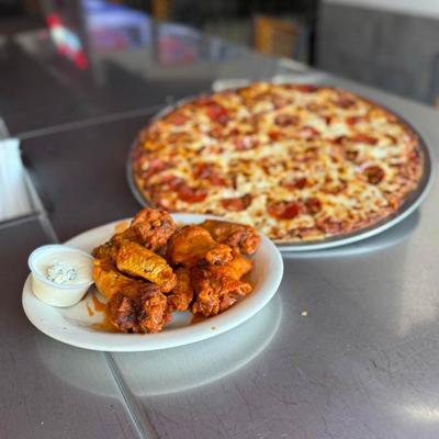 Pepperoni pizza paired with chicken wings and a side of creamy dip.